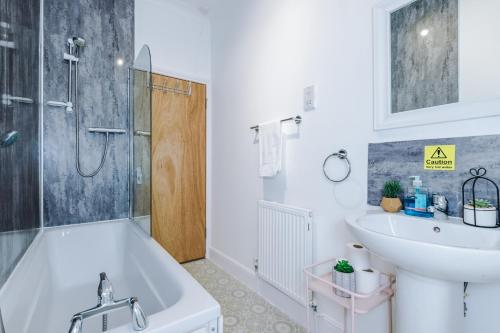 y baño con bañera, lavabo y aseo. en Stylish 3Bed Retreat - Walk to Coventry's Delights en Coventry