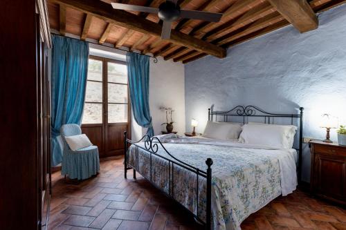 a bedroom with a large bed with blue curtains at Tenuta Aronne in Massa Marittima