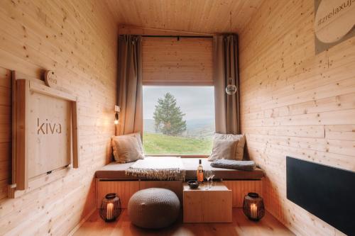 a room with a window with a bed and a table at kiva cabin in Horné Hámre