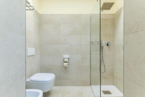 a bathroom with a toilet and a glass shower at Residence Le Acacie in Capoliveri