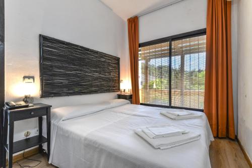 a bedroom with a bed and a large window at Residence Le Acacie in Capoliveri