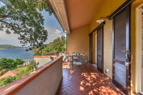 a balcony with a table and a view of the water at Residence Le Acacie in Capoliveri
