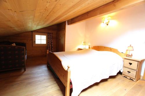 a bedroom with a bed and a wooden ceiling at Appartement Herbelands Est in Rougemont