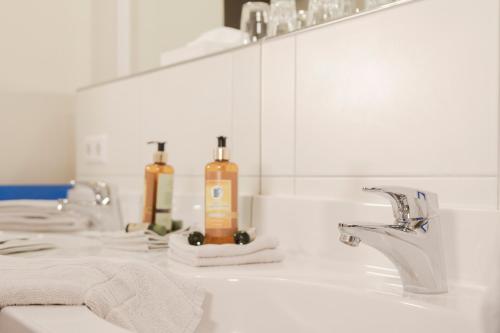a bathroom with two sinks and two bottles of soap at Brauereigasthof Krone in Tettnang