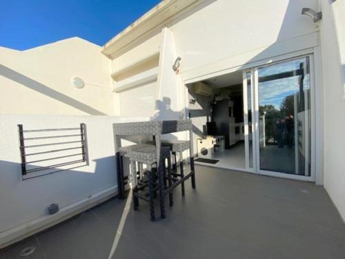 un balcon avec des chaises sur une maison blanche dans l'établissement Studio 7, Port Nature 1 au village naturiste, au Cap d'Agde