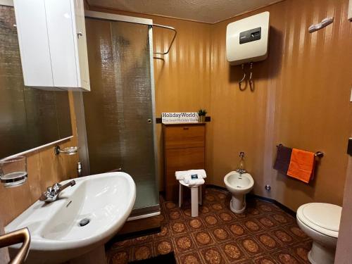 a bathroom with a sink and a toilet at House Betulle by Holiday World in Sella della Turra