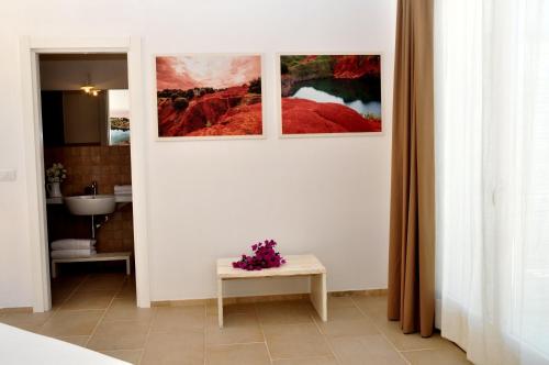 ein Badezimmer mit drei Bildern an der Wand in der Unterkunft Agriturismo La Turrita in SantʼAndrea