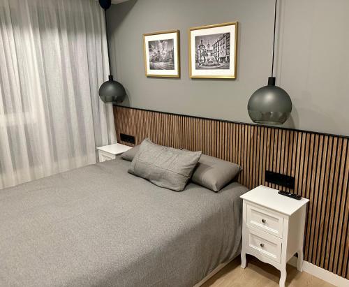 a bedroom with a bed with two night stands and two lamps at Apartamentos Universidad in Murcia