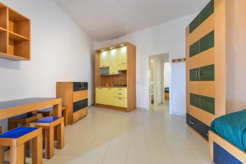 a kitchen and living room with yellow and green cabinets at Residence Le Acacie in Capoliveri