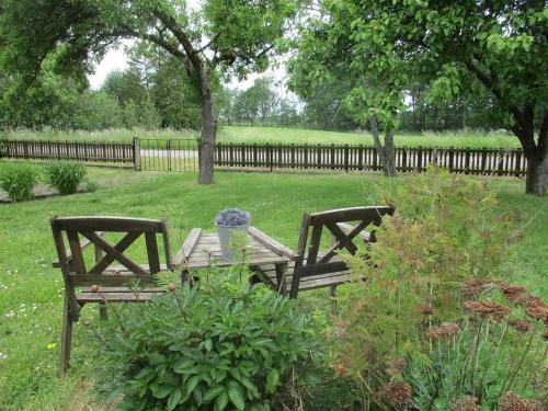 two wooden benches in a park with a fence at Påboda, Smaland, South Sweden in Söderåkra