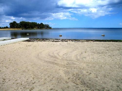 a sandy beach with two boats in the water at Påboda, Smaland, South Sweden in Söderåkra