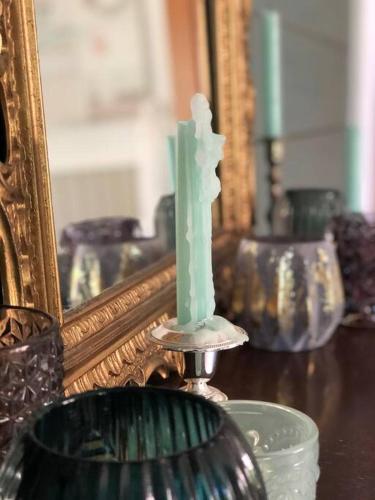 a candle sitting on a table in front of a mirror at Påboda, Smaland, South Sweden in Söderåkra