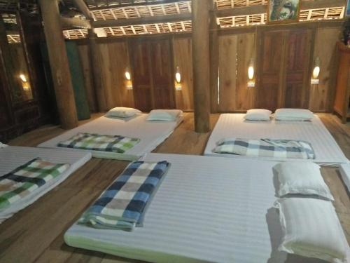 three beds in a room with wooden floors at Puluonghomestay2 in Làng Cào