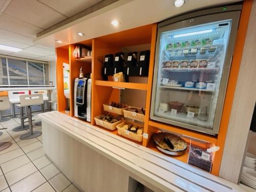 a display case in a restaurant with food at Premiere Classe Bordeaux Sud Villenave D'ornon in Villenave-dʼOrnon