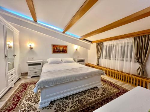 a bedroom with a large white bed and a window at Parc Vatra Dornei 2 - Family, couples & groups in Vatra Dornei