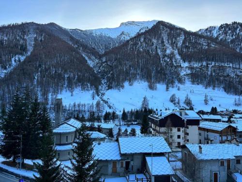 a village covered in snow with mountains in the background at Appartamento G&G in Pontechianale