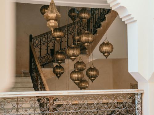 a staircase with gold chandeliers hanging from it at Sahara pearl Hotel in Merzouga