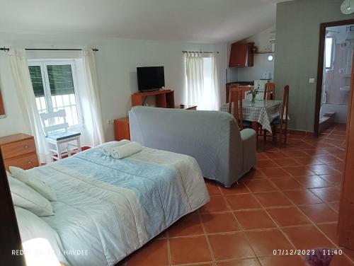 ein Schlafzimmer mit einem Bett und ein Wohnzimmer in der Unterkunft Casa El Azahin in Cazalla de la Sierra