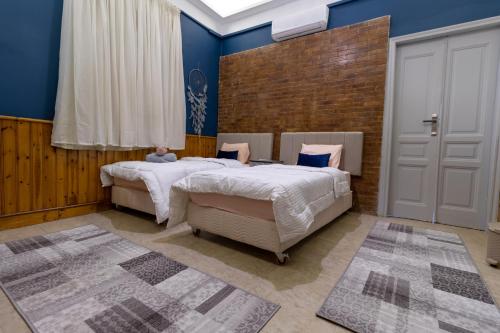 2 camas en un dormitorio con paredes azules en Villa Khufu Pyramids Inn en El Cairo