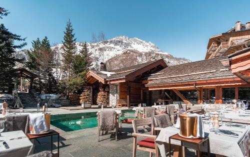 a restaurant with tables and chairs next to a pool at Hôtel LE BLIZZARD in Val dʼIsère