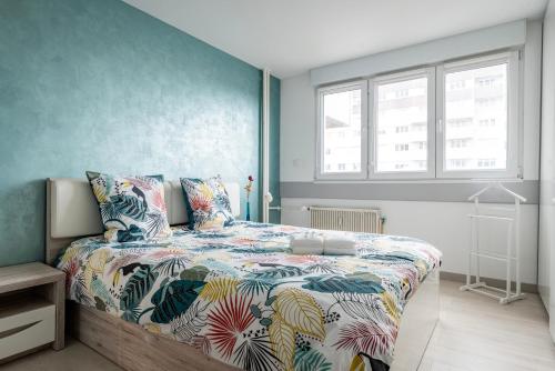 um quarto com uma cama com um edredão colorido em Famille, Parking, Balnéo - 15min Centre em Estrasburgo