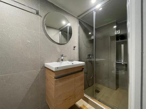 y baño con lavabo y ducha con espejo. en Nikitas loft en Kalamata