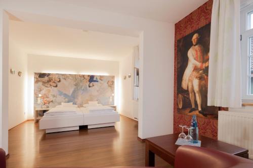 Habitación con 2 camas y una pintura en la pared. en Brauereigasthof Krone en Tettnang