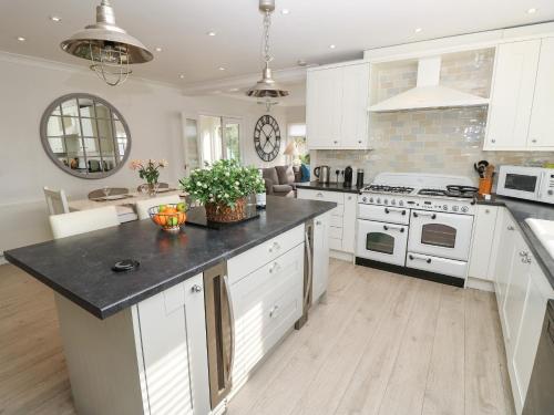 a kitchen with white cabinets and a black counter top at Burwyns in Ventnor