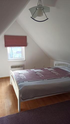 a bedroom with a bed in a attic with a window at Квартира Ворохта in Vorokhta