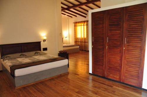 una camera con letto e grande armadio in legno di Asantha Guest House a Unawatuna