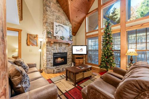 sala de estar con chimenea y árbol de Navidad en River's Creek Cabin, en Branson West