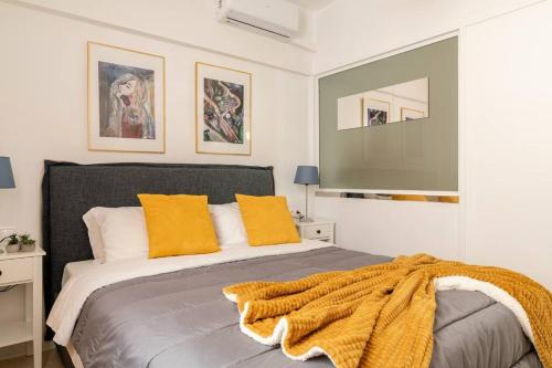 um quarto com uma cama com um cobertor em Brand New Bright modern 6bdr apt-1min to Acropolis em Atenas