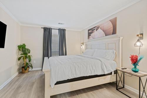 a white bedroom with a bed and a table at W - Atlanta Luxury 1bdr 1bath ensuite shared Condo in prime location in Atlanta