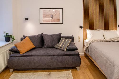 eine Couch neben einem Bett in einem Zimmer in der Unterkunft Modern Riverside Stays for 4 in Vilnius