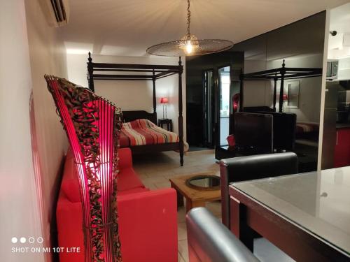- un salon avec un canapé rouge et un lit dans l'établissement Villa 112, Port Nature au Village Naturiste, au Cap d'Agde