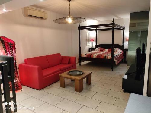 - un salon avec un canapé rouge et un lit dans l'établissement Villa 112, Port Nature au Village Naturiste, au Cap d'Agde