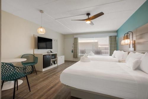 ワイルドウッドにあるHotel Cabana Oceanfront/Boardwalkの大型ベッドとテレビが備わるホテルルームです。