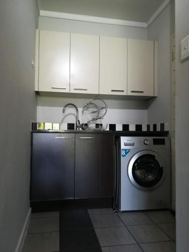 a kitchen with a washing machine and a sink at MANDITAZ STUDIO in Fourways