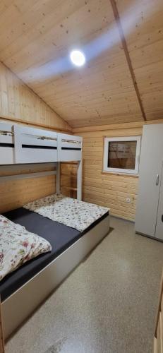 1 dormitorio con 1 cama en una habitación de madera en Jezioro Srebrne w Osowcu, en Turawa