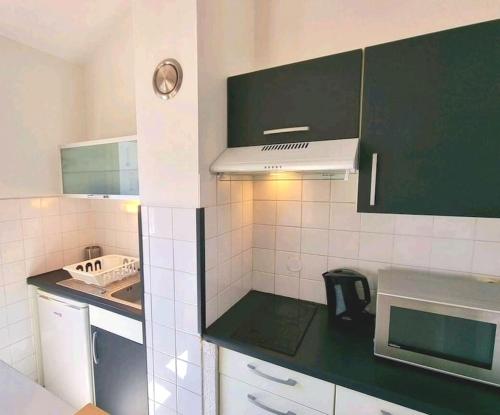 - une petite cuisine avec des appareils verts et blancs dans l'établissement Duplex Cosy - Toulouse, à Toulouse