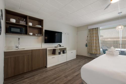 Habitación de hotel con cama, lavabo y TV. en Hotel Cabana Oceanfront/Boardwalk, en Wildwood