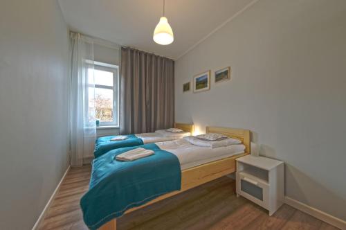 - une chambre avec 2 lits et une fenêtre dans l'établissement VacationClub – Lipowa 1 Apartament 3, à Wisła