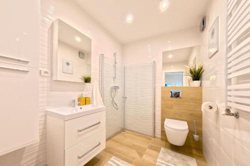 La salle de bains blanche est pourvue de toilettes et d'un lavabo. dans l'établissement VacationClub – Lipowa 1 Apartament 3, à Wisła
