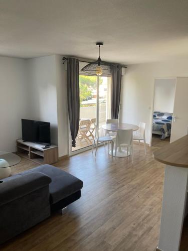 un salon avec un canapé et une table dans l'établissement Jolie T2 au golf de Seilh, à Seilh