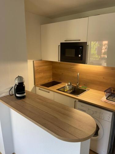 La cuisine est équipée d'un comptoir, d'un évier et d'un four micro-ondes. dans l'établissement Jolie T2 au golf de Seilh, à Seilh