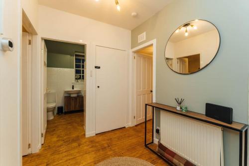 a room with a mirror on the wall and a sink at The Old Deanston Workers Cottage in Doune