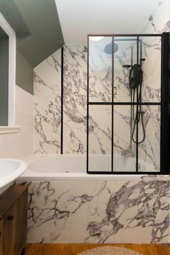 a bathroom with a sink and a marble wall at The Old Deanston Workers Cottage in Doune
