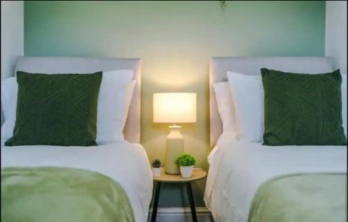 ein Schlafzimmer mit 2 Betten und einem Tisch mit einer Lampe in der Unterkunft St Helens - Cosy 1 Bed in Saint Helens