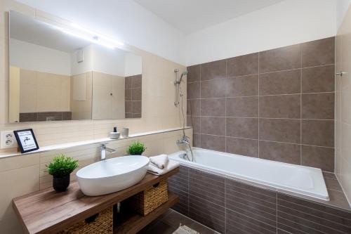 een badkamer met een witte wastafel en een bad bij Nova Karolina Apartment in Moravská Ostrava