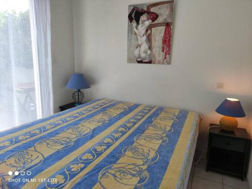 une chambre avec un lit et un tableau au mur dans l'établissement Villa 1, Natura Beach au village naturiste, au Cap d'Agde